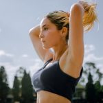 A focused woman in sportswear tying her hair, preparing for an outdoor workout in Mexico City.